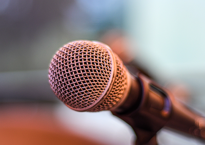 A microphone on a stand. The background is out of focus